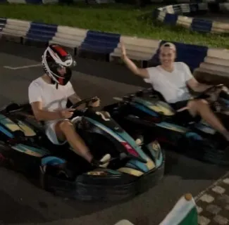 Eusebiu and a friend racing go-karts on an outdoor track at night